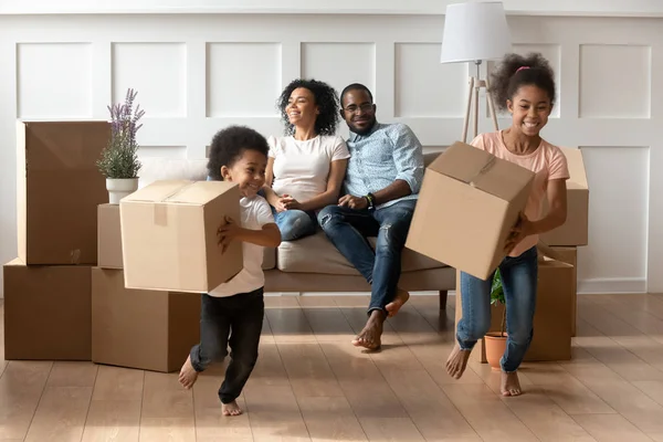 Happy little african kids holding boxes play on moving day — Stock Photo, Image
