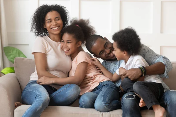 Felice famiglia afroamericana di quattro ridere legame sul divano — Foto Stock