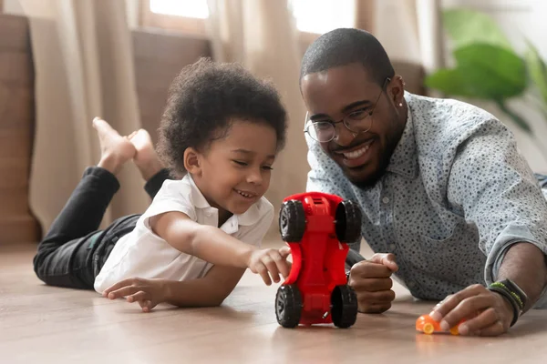 Schattige kleine Afrikaanse Kid zoon spelen speelgoed auto's met papa — Stockfoto