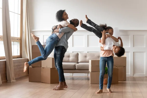 Padres africanos divertidos niños celebran el día de mudanza en casa nueva — Foto de Stock