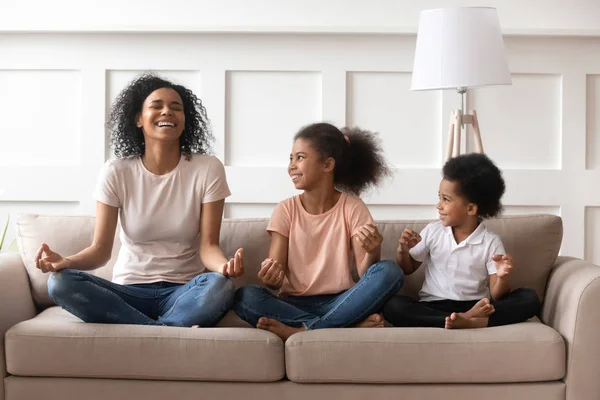 Feliz riendo solo negro mamá meditando con niños en casa — Foto de Stock