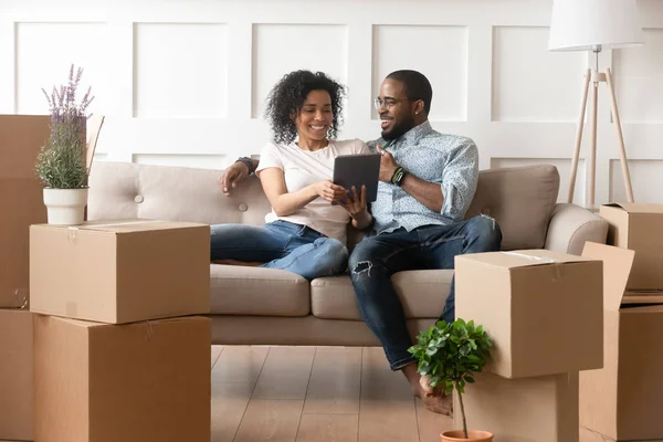 Smiling black couple use digital tablet on moving day — Stock Photo, Image