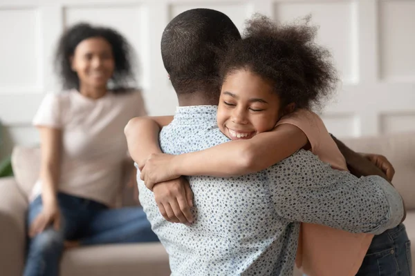 Feliz pequena criança africana filha abraçando o pai negro em casa — Fotografia de Stock