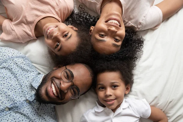 Mutlu Afrikalı aile yatakta kamera bakıyor, üst görünümü — Stok fotoğraf