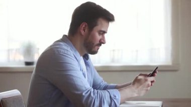 Kızgın kızgın genç adam sıkışmış kırık telefon ile sinirli