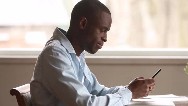 Emocionado hombre negro usando el teléfono inteligente se siente encantado con la victoria móvil — Vídeos de Stock