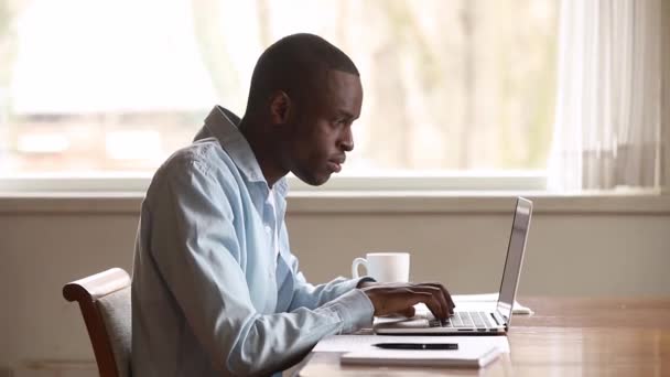 Frustrado molesto hombre negro usando portátil leyendo malas noticias en línea — Vídeos de Stock