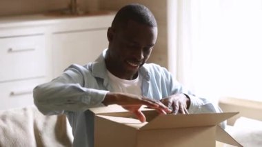 Mutlu afrikalı adam müşteri evde parsel karton kutu açık