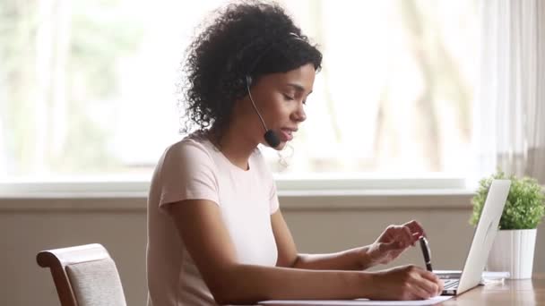 Mujer africana skype profesora con auriculares hablando mirando a la computadora portátil — Vídeos de Stock