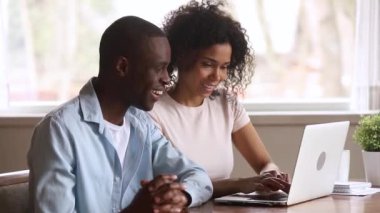 Online kazanmak tarafından heyecanlı dizüstü bakarak Öforik Afrikalı çift