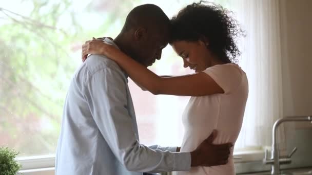 幸せな愛情のアフリカ系アメリカ人の若いカップルは、キッチンで抱き合う — ストック動画