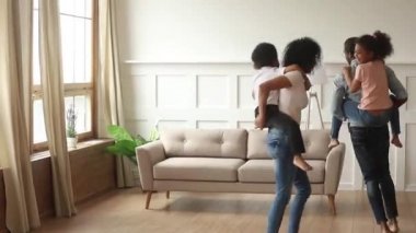 Mutlu Afrikalı anne-babalar piggyback çocuklar evde oynarken gülüyor