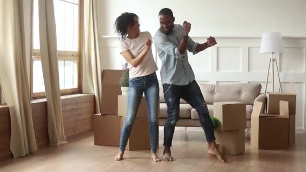 Africano casal primeira vez casa compradores dançando na sala de estar — Vídeo de Stock