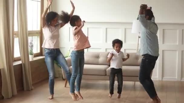 Ευτυχισμένοι Αφροαμερικανοί γονείς και χαριτωμένα παιδιά χορεύουν στο σπίτι — Αρχείο Βίντεο