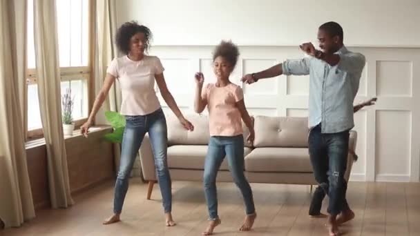 Zorgeloos zwarte ouders en kinderen dansen samen in de woonkamer — Stockvideo