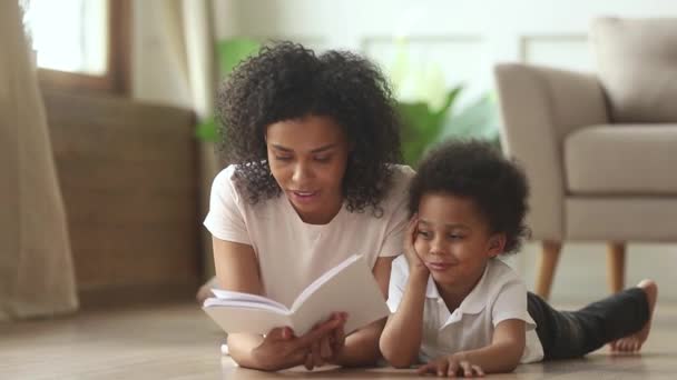Amor africano madre lectura libro a inteligente lindo niño hijo — Vídeo de stock
