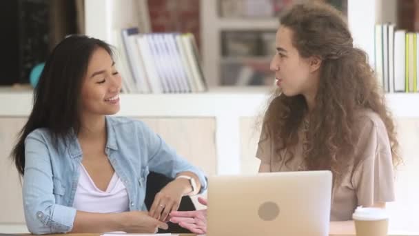 Zwei unterschiedliche Studentinnen im Gespräch beim gemeinsamen Lernen auf dem Campus — Stockvideo