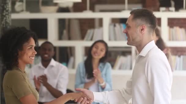 Kaukasische männliche Manager Lehrer Handschlag loben glückliche afrikanische Mitarbeiterin — Stockvideo