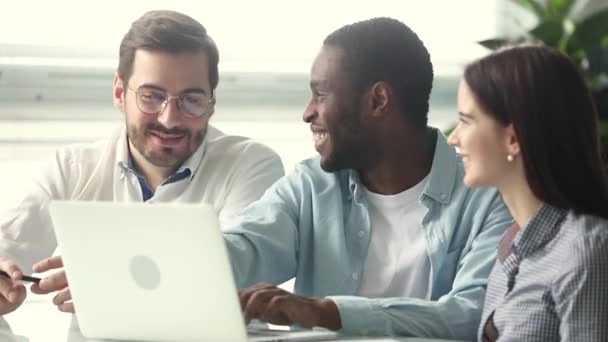 Sonriente mentor afroamericano enseñando pasantes apuntando al portátil — Vídeos de Stock