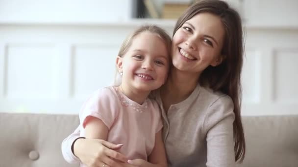 Happy mom and child daughter waving hands looking at camera — Stock Video