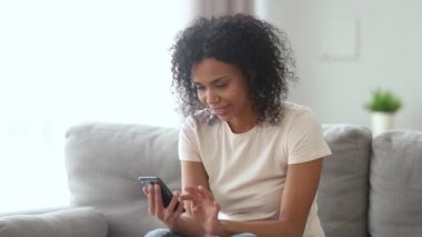 Mutlu Afrikalı kadın telefon partner uygulaması swiping heyecanlı hissediyorum