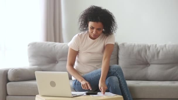 Ernstige Afrikaanse vrouw berekenen betalen binnenlandse rekeningen online op laptop — Stockvideo