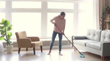 Modern oturma odasında Düzenli genç kadın ev hanımı temiz zemin
