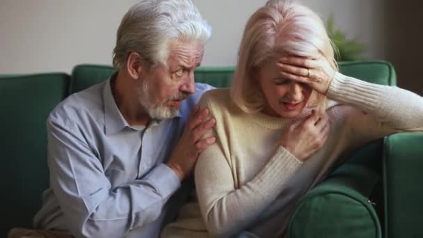 Любящий добрый старший муж утешает грустную плачущую жену средних лет — стоковое видео