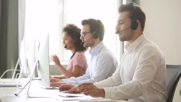 Hombre agente de centro de llamadas desgaste auriculares inalámbricos consultoría cliente — Vídeo de stock