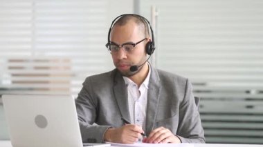 Ciddi Afrika müşteri destek acentesi müşteri ile konuşurken kulaklık takan
