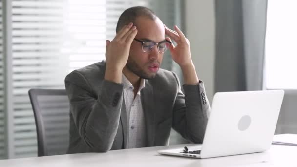 Empresário africano estressado sente dor de cabeça no trabalho olhando para laptop — Vídeo de Stock