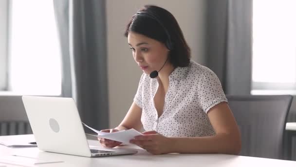 Sorrindo asiático mulher de negócios usar fone de ouvido falando olhando para laptop — Vídeo de Stock