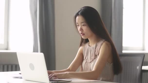 Emocionado asiático mujer de negocios ganador celebrando en línea ganar mirando el ordenador portátil — Vídeo de stock