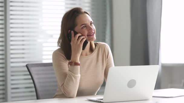Lachende duizendjarige zakenvrouw praten over de telefoon het maken van zakelijke oproep — Stockvideo