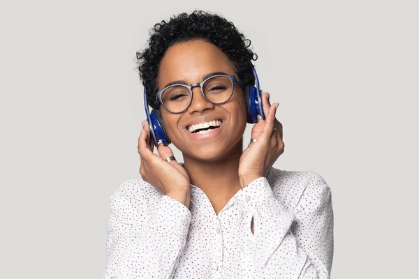 Souriant fille noire dans les écouteurs Bluetooth profiter de la musique — Photo