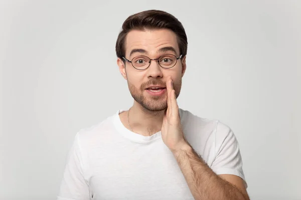 Chico en gafas susurrando cogido de la mano cerca de la boca estudio disparo — Foto de Stock