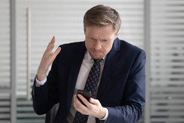 Kızgın stresli iş adamı takım elbise giymek telefon sorunu ile sinirli