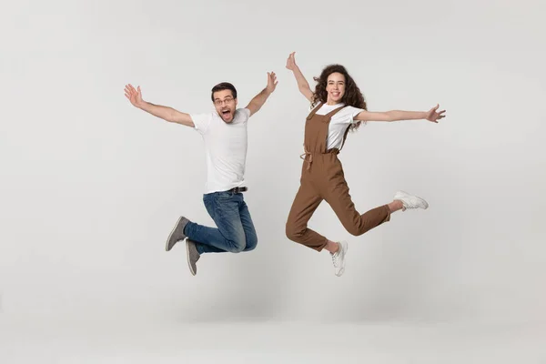 Couple was photographed in a jump isolated on grey background — Stock Photo, Image