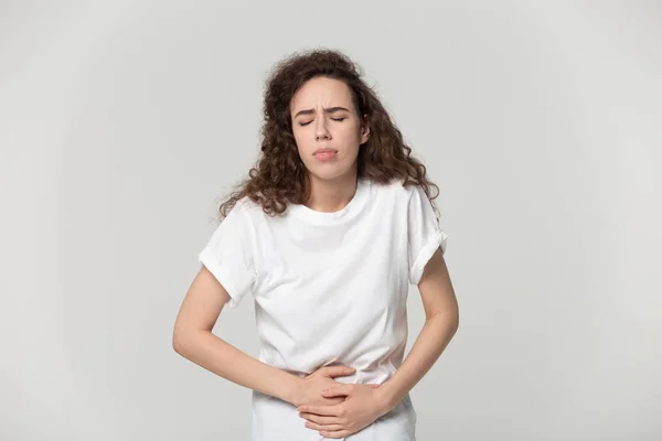 Kız gri izole şiddetli ağrı muzdarip mide dokunmadan — Stok fotoğraf