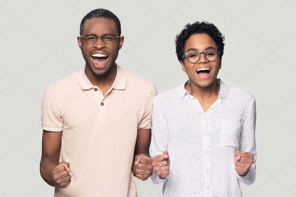 Overjoyed ethnic man and woman shout celebrating success