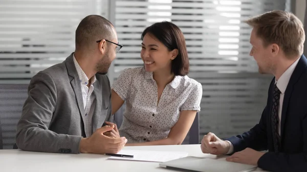 Excited mixed ethnicity couple customers decide on making business deal