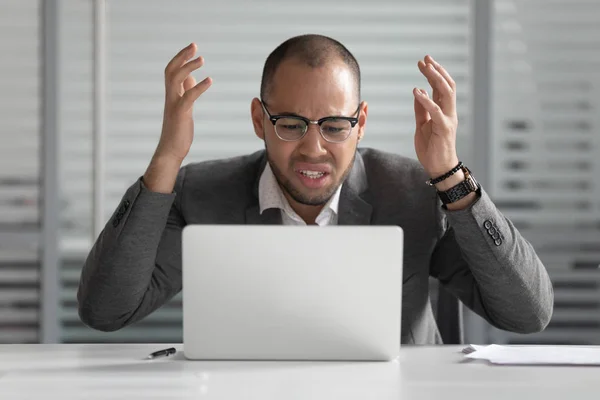 Homem de negócios africano irritado usando laptop louco sobre problema de computador — Fotografia de Stock