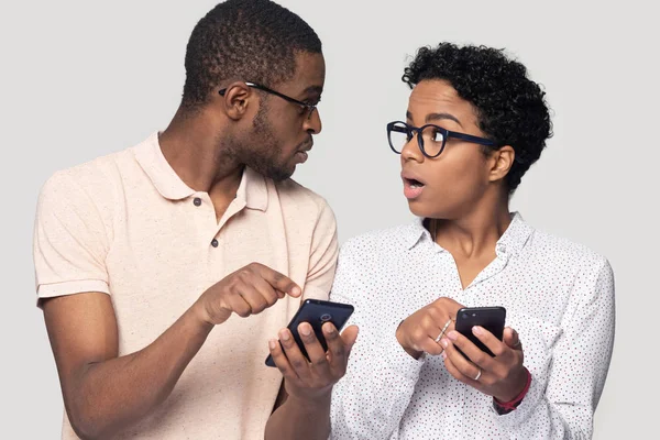 Şaşkın etnik çift akıllı telefonlarda mesaj almak şaşırttı — Stok fotoğraf