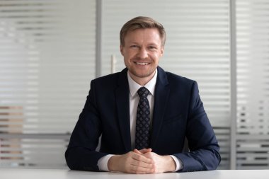 Gülümseyen orta yaşlı işadamı koç takım elbise kamera bakıyor