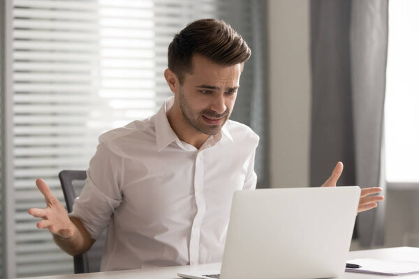 Angry stressed business man annoyed by computer problem in office
