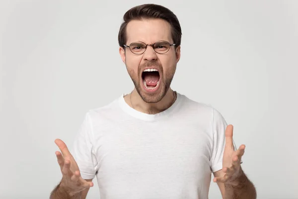 Screaming guy in glasses isolated on gray background — Stock Photo, Image