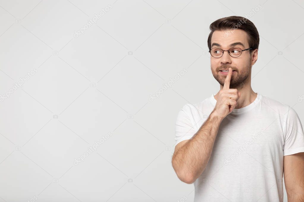 Man holds finger at lips showing be quiet gesture