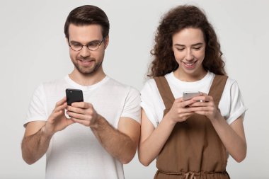 Gri stüdyo arka planda poz akıllı telefonlar kullanarak Bin yıllık çift