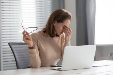 Yorgun stresli genç iş kadını sekreteri iş yerinde göz yorgunluğu hissediyorum
