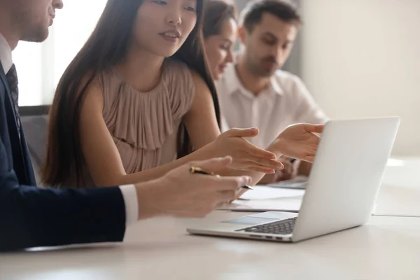 Negócios discussão, asiático empregado falando com colega apontando para laptop — Fotografia de Stock